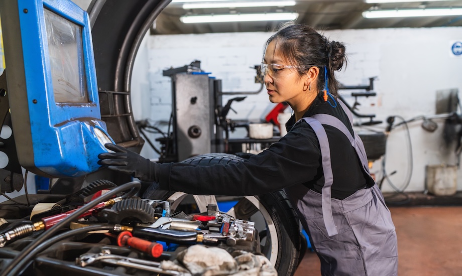 A mechanical engineer working with machinery in an auto repair shop