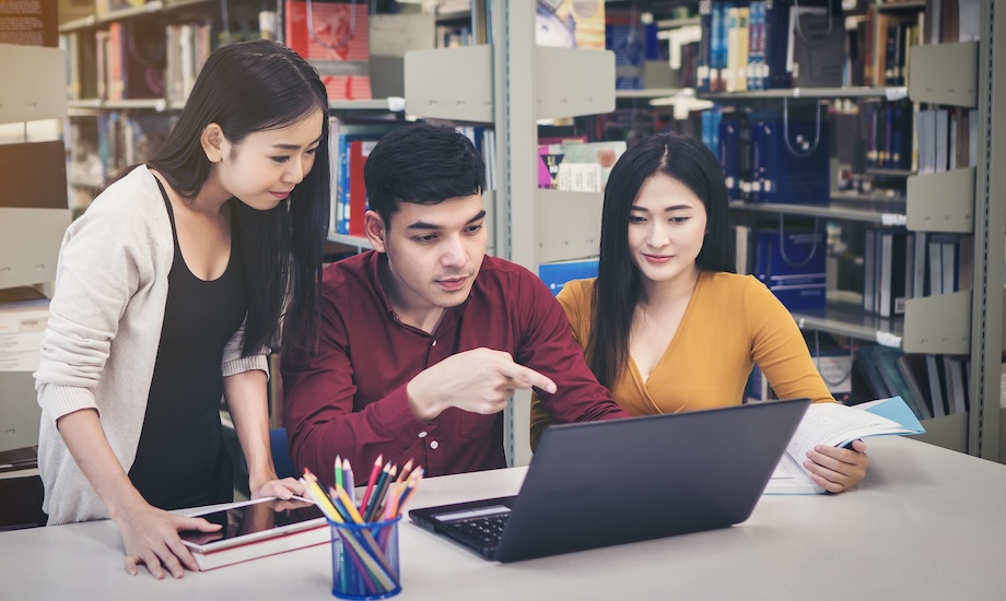 Students collaborating on an IT project in the library