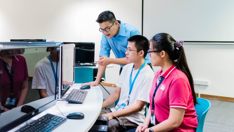 IT students collaborating with a lecturer during the class
