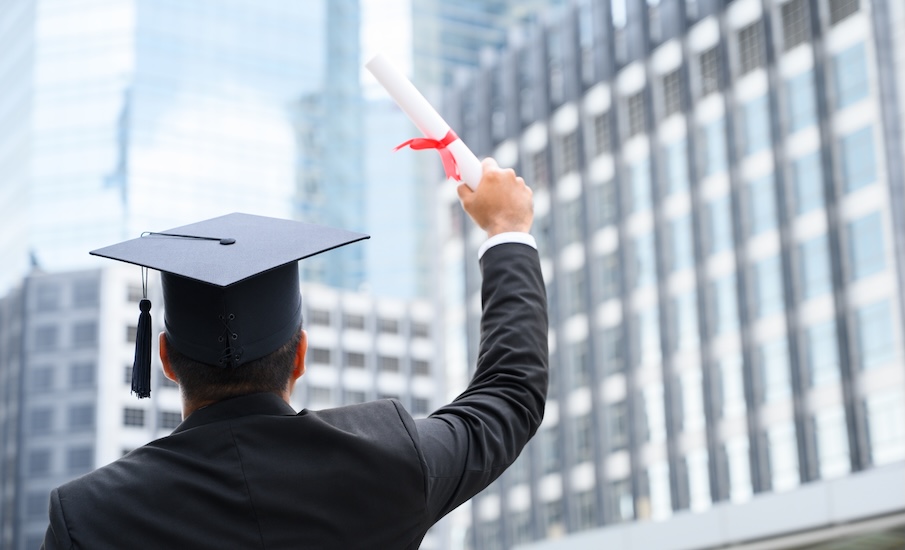 graduate holding his degree certificate in celebration