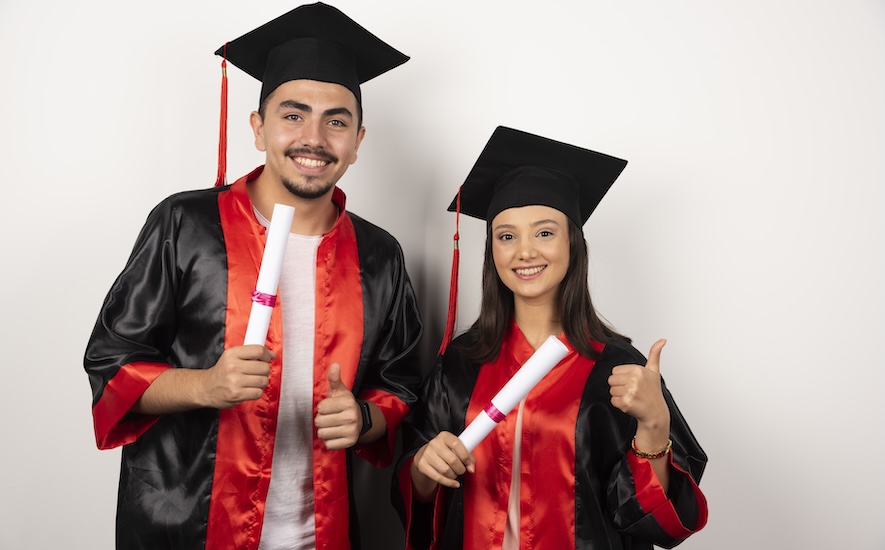 Two students celebrating their graduation, one with a double major and the other with a double degree