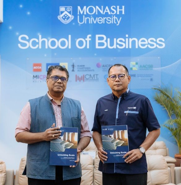 Professor Avvari V. Mohan and Kameel Abdul Halim pose for a photo holding the research reports on Green Affordable Housing in Malaysia.