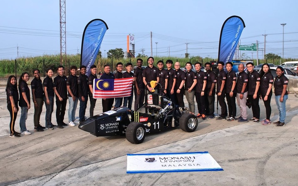 mechanical engineering students with a race car, showcasing teamwork