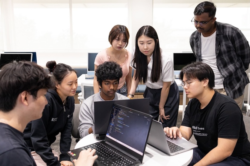 IT students collaborating and coding together in a study session